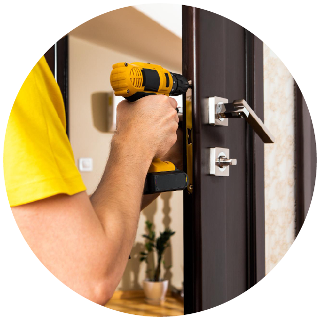 Un homme répare une poignée de porte, un bricoleur répare la serrure de la porte dans la chambre, travaille pour les réfugiés 